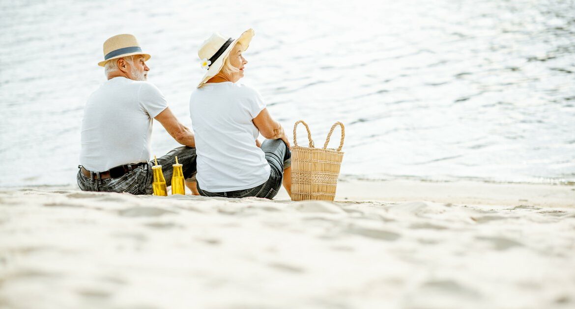 Deux personnes sont assises sur une plage près d’un panier.