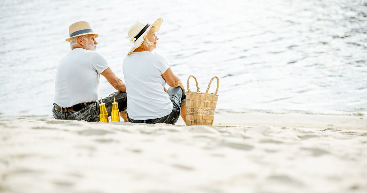 Deux personnes sont assises sur une plage près d’un panier.