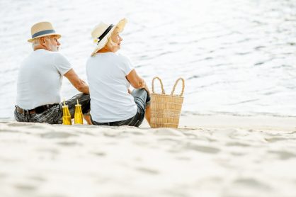 Deux personnes sont assises sur une plage près d’un panier.